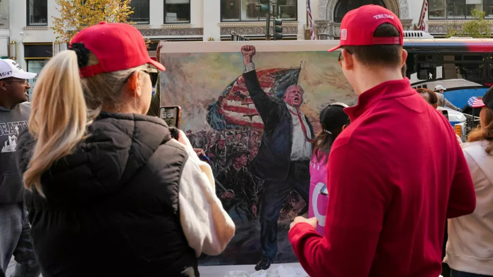 People look at an artwork depicting Republican presidential nominee and former U.S. President Donald Trump on the day of a rally for Trump, in New York, U.S., October 27, 2024. REUTERS/David Dee Delgado