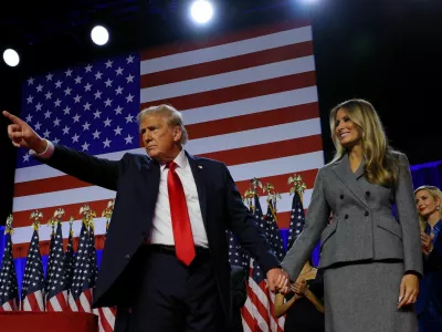 Republican presidential nominee and former U.S. President Donald Trump gestures as he holds hands with his wife Melania during his rally, at the Palm Beach County Convention Center in West Palm Beach, Florida, U.S., November 6, 2024. REUTERS/Brian Snyder   TPX IMAGES OF THE DAY
