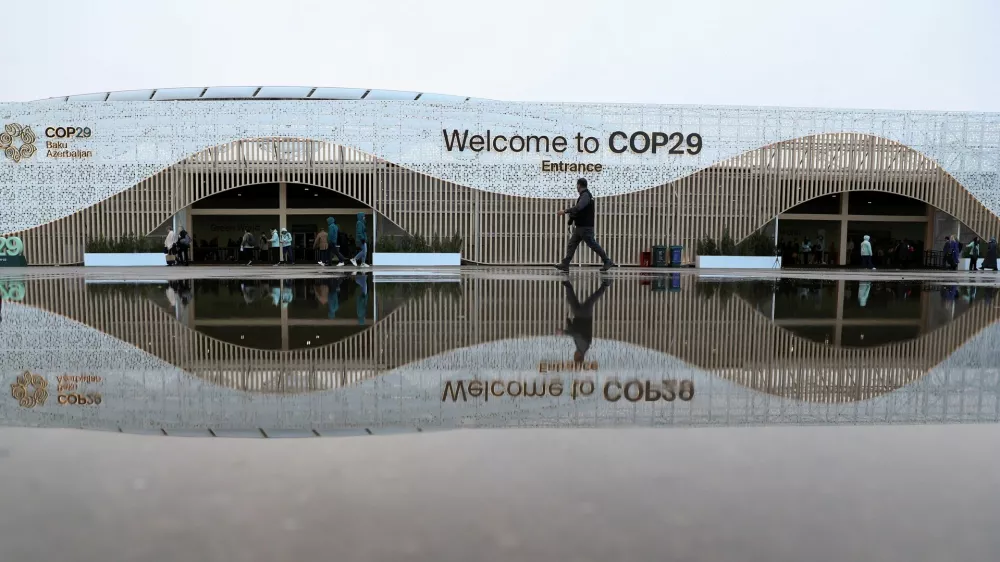 People walk in front of the venue of the United Nations climate change conference COP29, in Baku, Azerbaijan November 14, 2024. REUTERS/Aziz Karimov