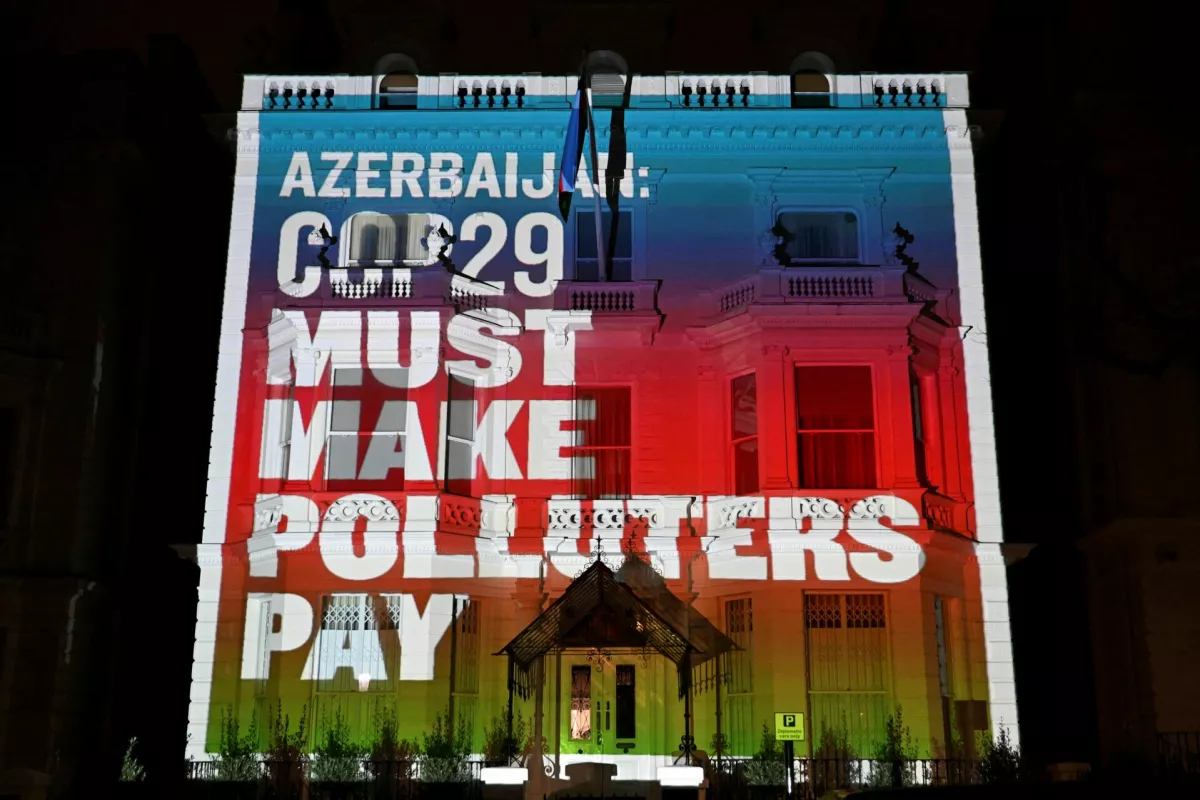 Podnebni aktivisti so na poslopje azerbajdžanskega veleposlani&scaron;tva v Londonu projicirali sporočilo, da mora leto&scaron;nji podnebni vrh v Bakuju poskrbeti za to, da bodo onesnaževalci plačali svoj po&scaron;teni delež. Foto: Reuters