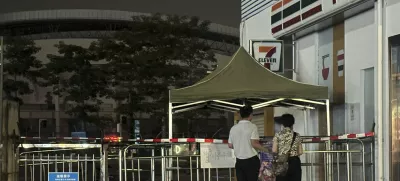 Pople look at barriers at the enter where a man deliberately rammed his car into people exercising, killed some and injured others in Zhuhai in southern China's Guangdong province, Tuesday, Nov. 12, 2024. (AP Photo/Ng Han Guan)