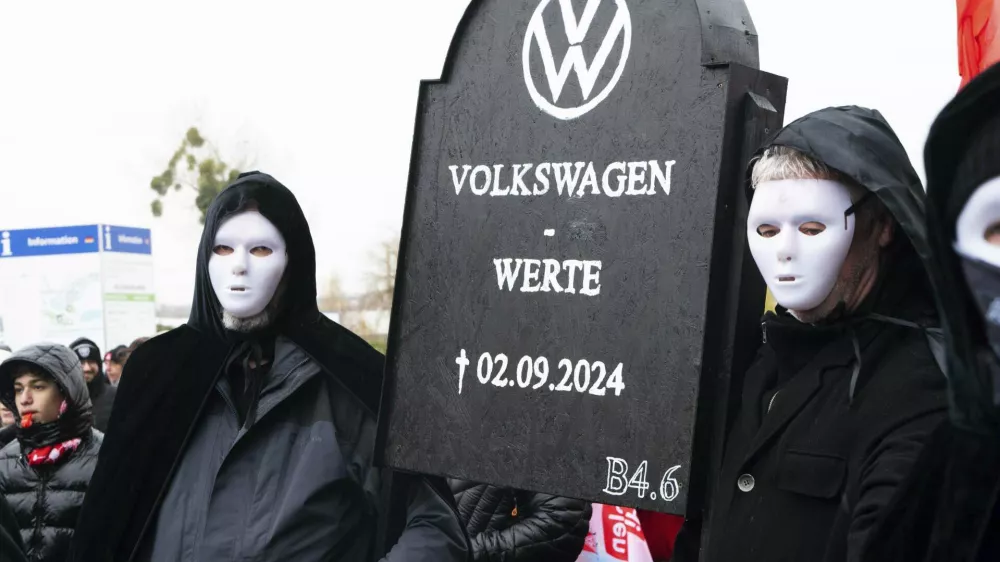 Volkswagen employees demonstrate in front of the Volkswagen Arena in Wolfsburg during the wage negotiations between Volkswagen and IG Metall, Tursday, Nov. 21, 2024. (Alicia Windzio/dpa via AP)