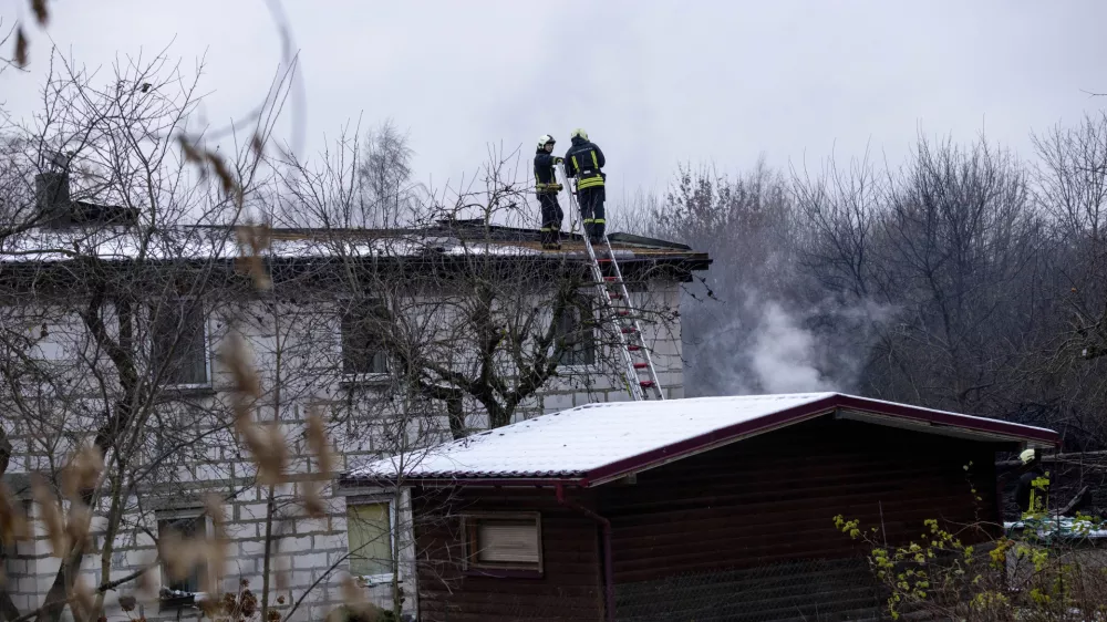 Lithuanian Emergency Ministry employees work at the site where a DHL cargo plane crashed into a house near Vilnius, Lithuania, Monday, Nov. 25, 2024. (AP Photo/Mindaugas Kulbis)