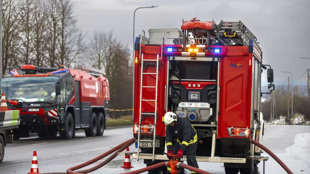 Lithuanian emergency personnel prepare to work near the site where a DHL cargo plane crashed into a house near the Lithuanian capital Vilnius, Lithuania, Monday, Nov. 25, 2024. (AP Photo/Mindaugas Kulbis)