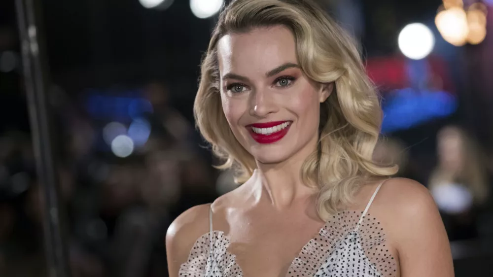 FILE - In this Monday, Dec. 10, 2018, file photo, actress Margot Robbie poses for photographers upon her arrival at the premiere of the film "Mary Queen of Scots," in London. Robbie will bring the Barbie doll to life in a live-action film. Mattel and Warner Bros. Pictures announced Tuesday, Jan. 8, 2019, that Robbie will star as the iconic doll in the franchise&acirc;&euro;&trade;s first-ever live-action film. The 28-year-old &acirc;&euro;śSuicide Squad&acirc;&euro;ť actress will also co-produce the film under her LuckyChap Entertainment banner. (Photo by Vianney Le Caer/Invision/AP, File)
