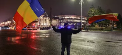 A man waves Romanian flags at Victory Square, after the annulment of the presidential election result, in Bucharest, Romania, December 6, 2024. REUTERS/Louisa Gouliamaki