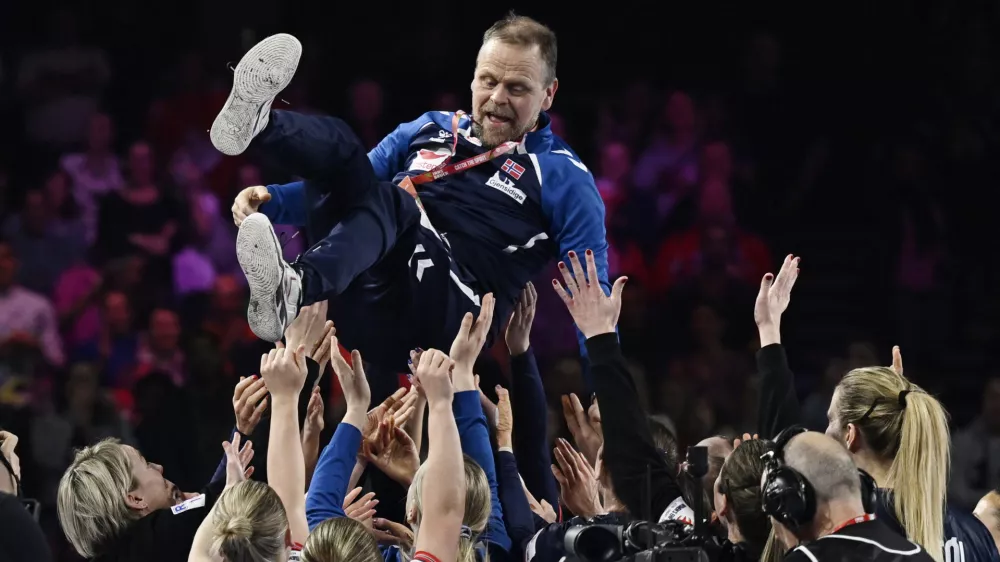 Odhajajoči norve&scaron;ki selektor, Islandec Thorir Hergeirsson, se je po finalni zmagi proti Danski na Dunaju zna&scaron;el na rokah navdu&scaron;enih igralk. Foto: Reuters