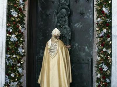 Cardinal Baldassare Reina opens the Holy Door of Rome's St. John in Lateran Basilica as part of the celebrations for the 2025 Jubilee of the Catholic Church, Sunday, Dec. 29, 2024. (Angelo Carconi/Pool Photo via AP)