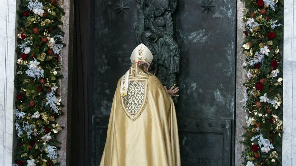 Cardinal Baldassare Reina opens the Holy Door of Rome's St. John in Lateran Basilica as part of the celebrations for the 2025 Jubilee of the Catholic Church, Sunday, Dec. 29, 2024. (Angelo Carconi/Pool Photo via AP)