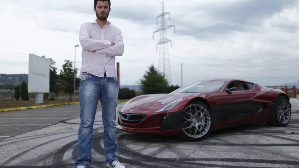 Mate Rimac owner of Rimac Automobili poses with the Concept One car in Zagreb August 31, 2012. Croatian concept car manufacturer Rimac Automobili based near Zagreb prepares to unveil a prototype of their Concept One electric supercar at the upcoming Salon Priv&eacute; car show in London in early September.The Concept One has a carbon fiber body an electric motor powering each wheel, and can produce 1,088 horse powers, capable of achieving top speed of around 305 kmh (190 mph) with a range of 600 kilometres (373 miles), making it the world's fastest electric car. Costing around $1 million each, only 13 of these high-end electric cars are expected to be produced per year. Picture taken August 31, 2012. REUTERS/Antonio Bronic (CROATIA - Tags: TRANSPORT BUSINESS) - RTR37CTI