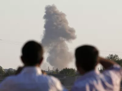 Turkish Kurds standing on the outskirts of Suruc, on the Turkey-Syria border, watch smoke rise following an airstrike in Kobani, Syria, where the fighting between militants of the Islamic State group and Kurdish forces intensified, Tuesday, Oct. 7, 2014. Kobani, also known as Ayn Arab and its surrounding areas have been under attack since mid-September, with militants capturing dozens of nearby Kurdish villages. (AP Photo/Lefteris Pitarakis)