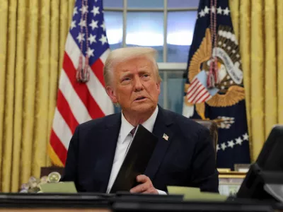 FILE PHOTO: U.S. President Donald Trump signs documents as he issues executive orders and pardons for January 6 defendants in the Oval Office at the White House on Inauguration Day in Washington, U.S., January 20, 2025. REUTERS/Carlos Barria//File Photo