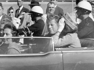 FILE - President John F. Kennedy waves from his car in a motorcade in Dallas, with first lady Jacqueline Kennedy, right, Nellie Connally, second from left, and her husband, Texas Gov. John Connally, far left, Nov. 22, 1963. (AP Photo/Jim Altgens, File)