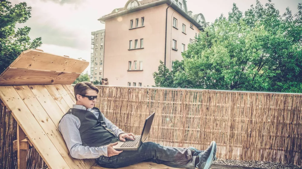 Working on a laptop at home, working on a terrace / Foto: Miha9000