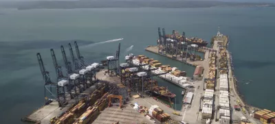 Cargo containers sit stacked as cranes load and unload containers from cargo ships at the Cristobal port, operated by the Panama Ports Company, in Colon, Tuesday, Panama, Feb. 4, 2025. (AP Photo/Matias Delacroix)