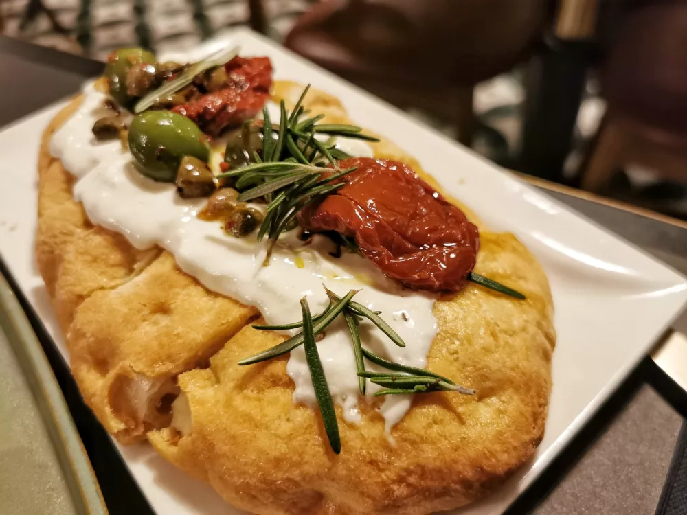 Fokača s stracciatello, su&scaron;enimi paradižniki, olivami, kaprami in rožmarinom, Papillon Bistrot