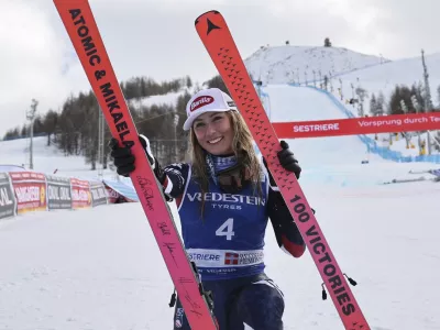 United States' Mikaela Shiffrin poses with her commemorative skis for her 100th victory after an alpine ski, women's World Cup slalom, in Sestriere, Italy, Sunday, Feb. 23, 2025. (AP Photo/Marco Trovati)