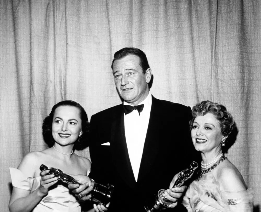 John Wayne je prevzel nagrado v imenu Garyja Cooperja. Na fotografiji z Janet Gaynor in Olivio de Havilland.&nbsp;/ Foto: Profimedia