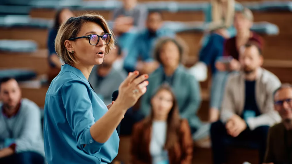Mid adult businesswoman talking to group of seminar attendees in conference hall. / Foto: Drazen Zigic