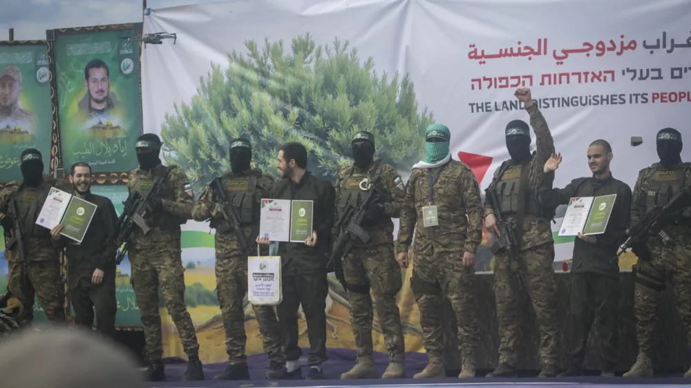 Israeli hostages, from left to right, Eliya Cohen, Omer Shem and Omer Wenkert, show Hamas issued certificates as instructed by militants, before being handed over to the Red Cross in Nuseirat, central Gaza Strip, Saturday, Feb. 22, 2025. (AP Photo/Jehad Alshrafi)