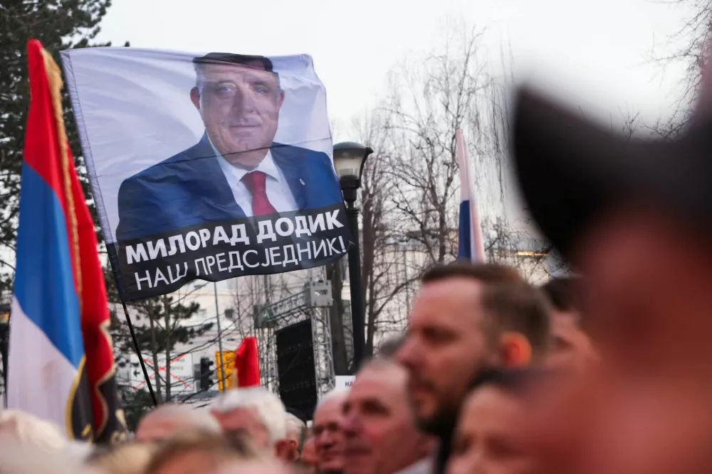 A person waves a flag as Bosnian Serbs rally in front of the regional parliament in support of President of Republika Srpska (Serb Republic) Milorad Dodik, a day ahead of his court verdict on charges that he defied rulings by an international peace envoy, in Banja Luka, Bosnia and Herzegovina, February 25, 2025. REUTERS/Amel Emric