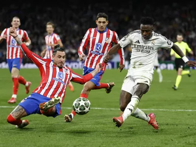 Soccer Football - Champions League - Round of 16 - First Leg - Real Madrid v Atletico Madrid - Santiago Bernabeu, Madrid, Spain - March 4, 2025 Atletico Madrid's Jose Maria Gimenez in action with Real Madrid's Vinicius Junior REUTERS/Juan Medina