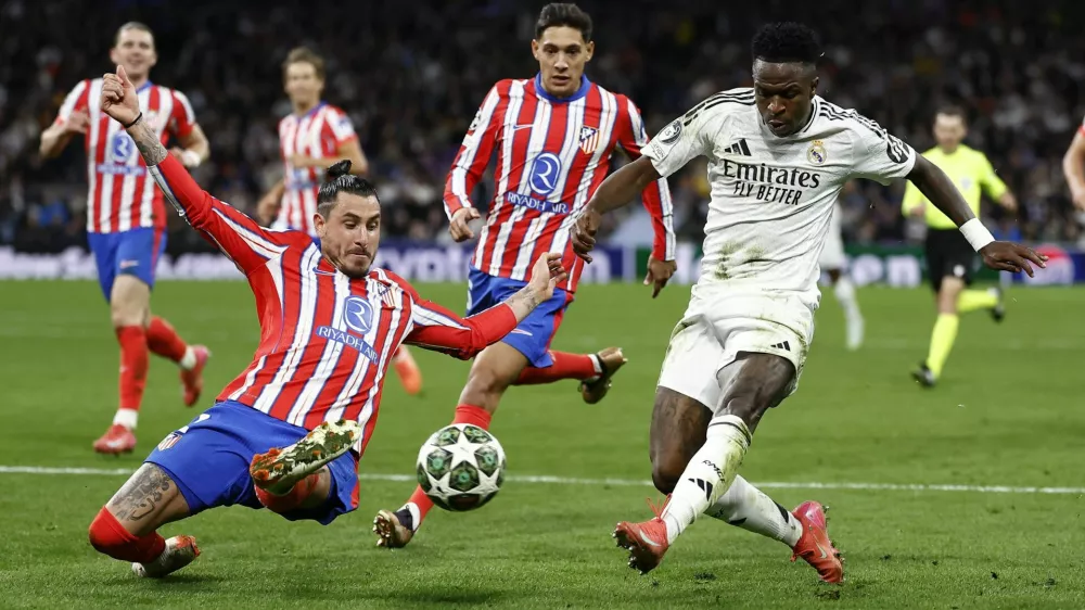 Soccer Football - Champions League - Round of 16 - First Leg - Real Madrid v Atletico Madrid - Santiago Bernabeu, Madrid, Spain - March 4, 2025 Atletico Madrid's Jose Maria Gimenez in action with Real Madrid's Vinicius Junior REUTERS/Juan Medina