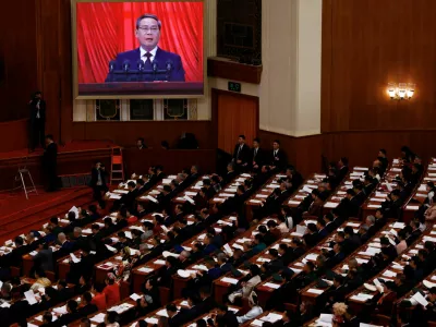 A screen shows Chinese Premier Li Qiang delivering a speech during the opening session of the National People's Congress (NPC) at the Great Hall of the People in Beijing, China, March 5, 2025. REUTERS/Tingshu Wang