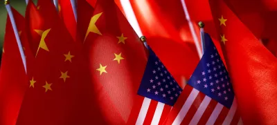 In this Sept. 16, 2018, photo, American flags are displayed together with Chinese flags on top of a trishaw in Beijing. The American Chamber of Commerce in China says Beijing will "dig its heels in" after U.S. tariff hikes and appealed for a negotiated end to their trade battle. The chamber on Tuesday, Sept. 18 warned a "downward spiral" appears certain after President Donald Trump approved a tariff hike on 0 billion of Chinese imports in a dispute over Beijing's technology policy. (AP Photo/Andy Wong)