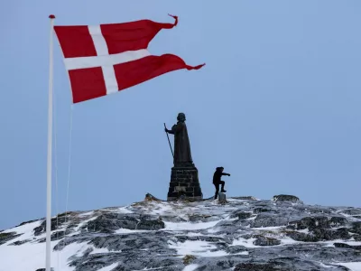 FILE PHOTO: A man walks as Danish flag flutters next to Hans Egede Statue ahead of a March 11 general election in Nuuk, Greenland, March 9, 2025. REUTERS/Marko Djurica/File Photo