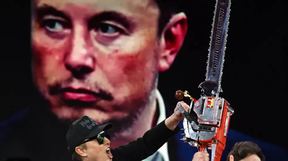 21 February 2025, US, Oxen Hill: Elon Musk is given a chainsaw as a gift by Argentine President Javier Millei during his appearance at CPAC, the annual Conservative Political Action Conference at the Gaylord Convention Center in Oxen Hill MD. Photo: Carol Guzy/ZUMA Press Wire/dpa