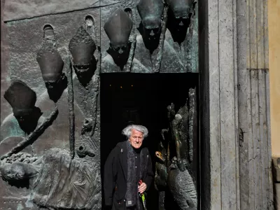 Dvainsedemdesetletni kipar Mirsad Begić pri stranskih vratih v ljubljansko stolnico, ki veljajo za tisto njegovo stvaritev, na katero je najbolj ponosen. Foto: Bojan Velikonja