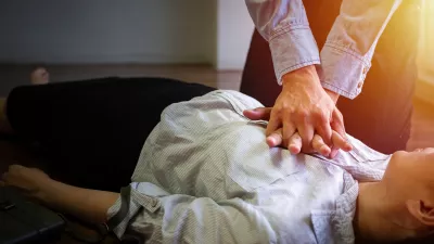 volunteer office man use hand pump on chest for first aid emergency CPR on heart attack woman unconscious, try to resuscitation patient woman at work / Foto: Asiandelight