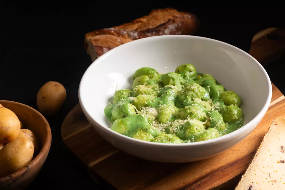 Food concept Spot focus Homemade creamy pesto gnocchi on black background with copy space / Foto: Buddyb76