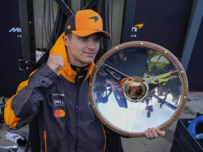 McLaren driver Lando Norris of Britain poses with his trophy after winning the Australian Formula One Grand Prix at Albert Park, in Melbourne, Australia, Sunday, March 16, 2025. (AP Photo/Asanka Brendon Ratnayake)