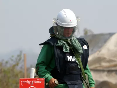 Cambodian woman On Sovannareth, 30, searches for mines in a minefield near the village of Ta Krouk, some 350km northwest of the capital Phnom Penh. As a member of what is one of the world's first all-women demining teams, she is working to clear mines and unexploded bombs left from decades of conflict in the impoverished southeast Asian nation. Picture taken February 11, 2004. TO MATCH FEATURE CAMBODIA-MINES REUTERS/Chor Sokunthea