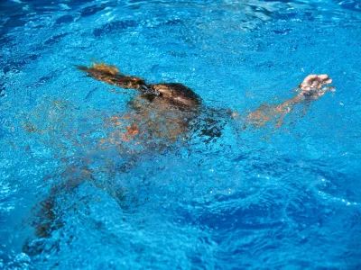 2B2CN23 Little girl drowning in water while swimming in the pool or sea.