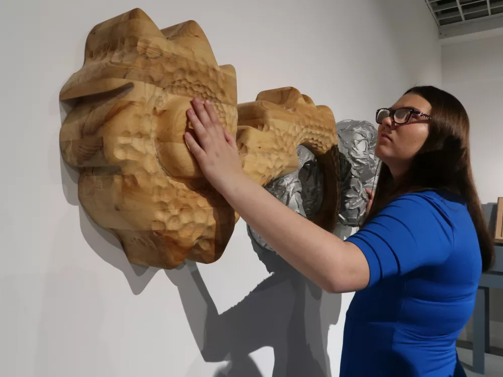 Slepa dijakinja Zara Smrtnik si je vzela čas, da otipa delo umetnice Nike &Scaron;imac, ki je z lipovim lesom in aluminijem pričarala igro dneva in noči.&nbsp;/ Foto: Nata&scaron;a Bucik Ozebek