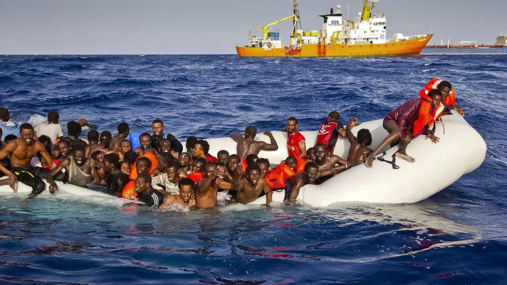 In this photo taken on Sunday, April 17, 2016 migrants ask for help from a dinghy boat as they are approached by the SOS Mediterranee's ship Aquarius, background, off the coast of the Italian island of Lampedusa. The European Union's border agency says the number of migrants crossing the Mediterranean Sea to Italy more than doubled last month. Frontex said in a statement on Monday that almost 9,600 migrants attempted the crossing, one of the most perilous sea voyages for people seeking sanctuary or jobs in Europe. (Patrick Bar/SOS Mediterranee via AP)