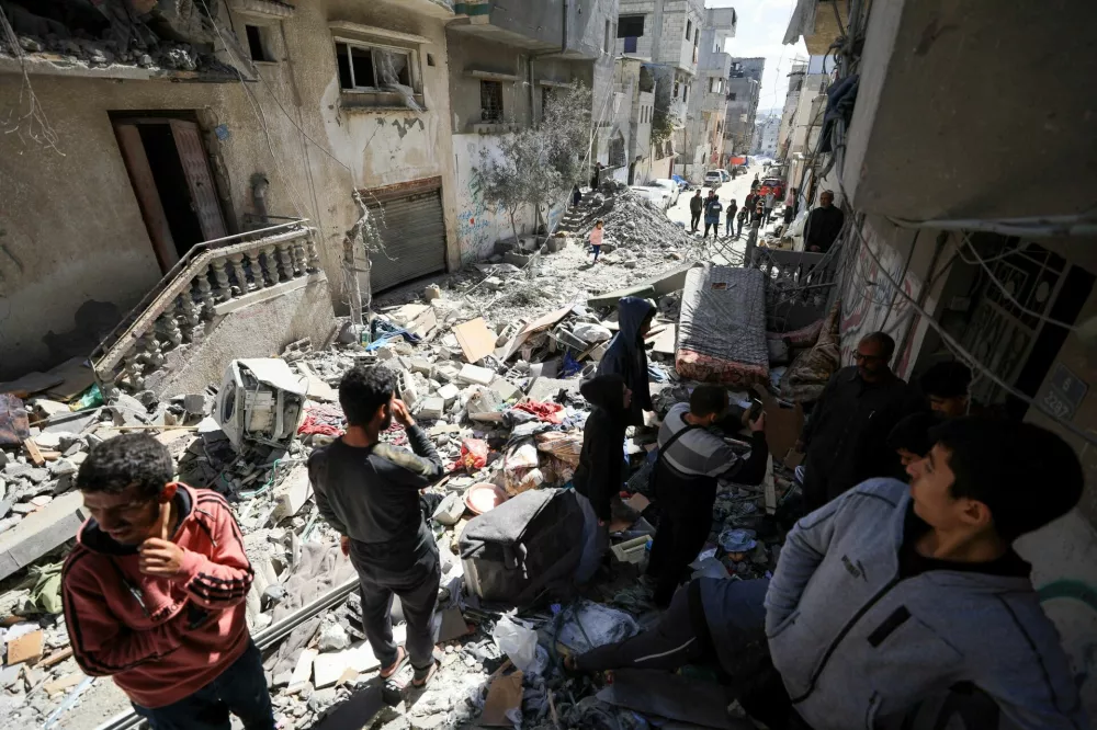 Palestinians gather at the site of an Israeli strike on a residential building in Gaza City, March 19, 2025. REUTERS/Dawoud Abu Alkas   TPX IMAGES OF THE DAY
