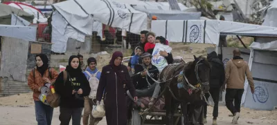 Displaced Palestinians, carrying their belongings, move away from the areas where the Israeli army is operating after Israel's renewed offensive in the Gaza Strip, on the outskirts of Beit Lahia, Thursday, March 20, 2025. (AP Photo/Jehad Alshrafi)