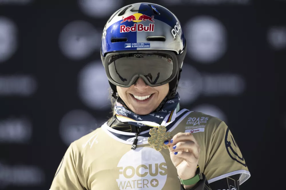 Gold medalist Ester Ledecka of Czech Republic poses at the Snowboard Parallel Giant Slalom competition at the FIS Snowboard, Freestyle and Freeski World Championships, in St. Moritz, Switzerland, Thursday, March 20, 2025. (Gian Ehrenzeller/Keystone via AP)