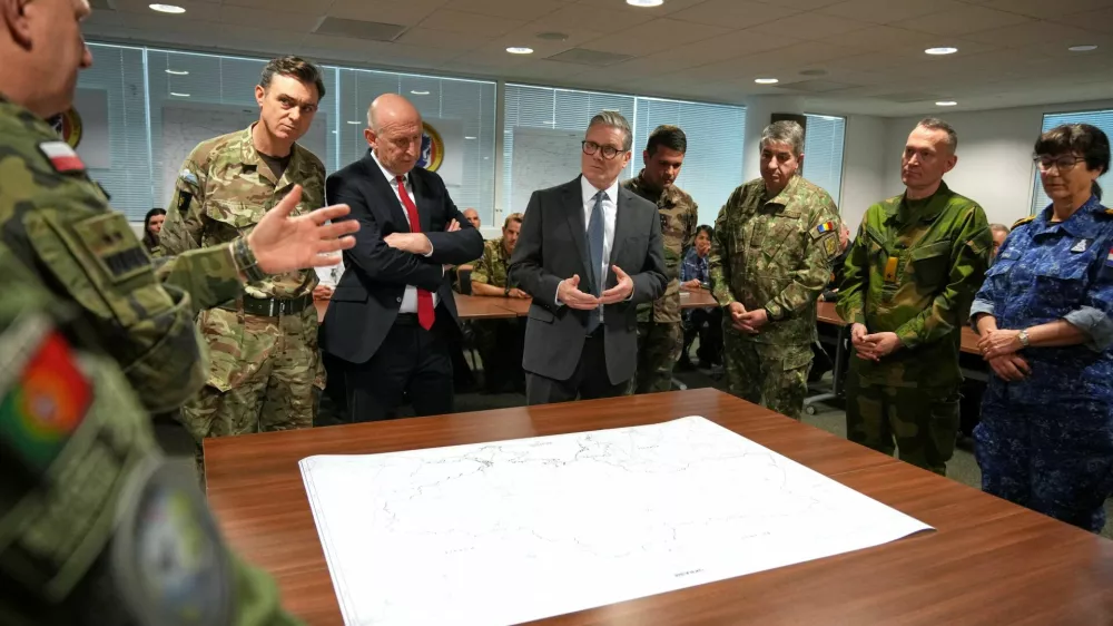 Britain?s Prime Minister Keir Starmer and Defence Secretary John Healey listen as they visit a military base to meet planners mapping out next steps in the Coalition of the Willing in Greater London, Britain, March 20, 2025.  Alastair Grant/Pool via REUTERS