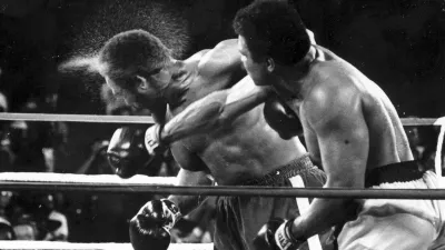 FILE - Perspiration flies from the head of George Foreman as he takes a right from challenger Muhammad Ali in the seventh round in the match dubbed Rumble in the Jungle in Kinshasa, Zaire, Oct. 30, 1974. (AP Photo/Ed Kolenovsky, File)