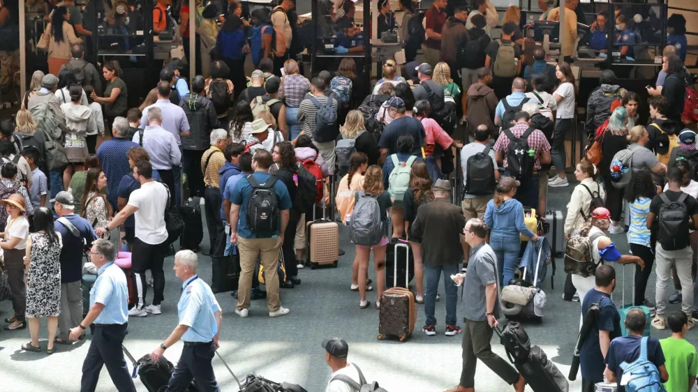 FILE - Travelers wait in line for security in the east hall atrium at Orlando International Airport, Thursday, May 25, 2023 in Orlando, Fla. (Joe Burbank /Orlando Sentinel via AP, File)