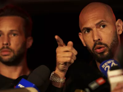 Andrew Tate, right, speaks to media next to his brother Tristan, after returning from the United States, outside his home on the outskirts of Bucharest, Romania, Saturday, March 22, 2025. (AP Photo/Vadim Ghirda)