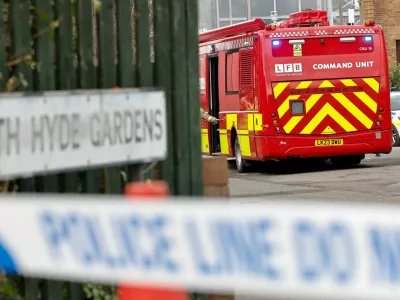 Police officers and firefighters work by the entrance to an electrical substation, a day after it caught fire and wiped out power at Heathrow International Airport, near London, Britain, March 22, 2025. REUTERS/Carlos Jasso