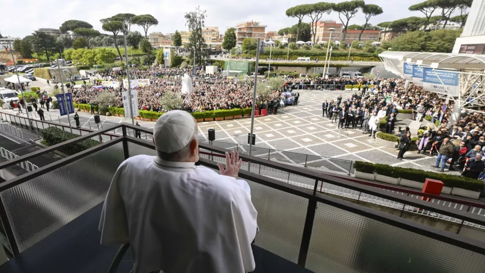 Pope Francis waves as he appears at a window of the Agostino Gemelli Polyclinic in Rome, Sunday, March 23, 2025, where he has been treated for bronchitis and bilateral pneumonia since Feb. 14. (Francesco Sforza/Vatican press office via AP)