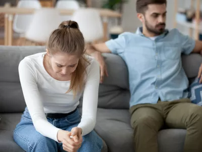 Unhappy young millennial married couple sitting on couch in living room after quarrel fight. Angry husband frustrated offended wife at home. Break up, divorce and misunderstanding in relations concept / Foto: Fizkes