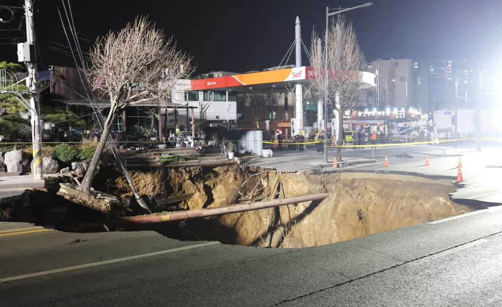 24 March 2025, South Korea, Seoul: Rescue work is underway at a 20-meter-wide sinkhole at an intersection in Seoul, Gangdong district of South Korea, after it opened up and swallowed a motorcyclist. Photo: -/Yonhap/dpa